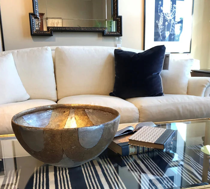 Living room with a white sofa, decorative bowl on a coffee table, and books.