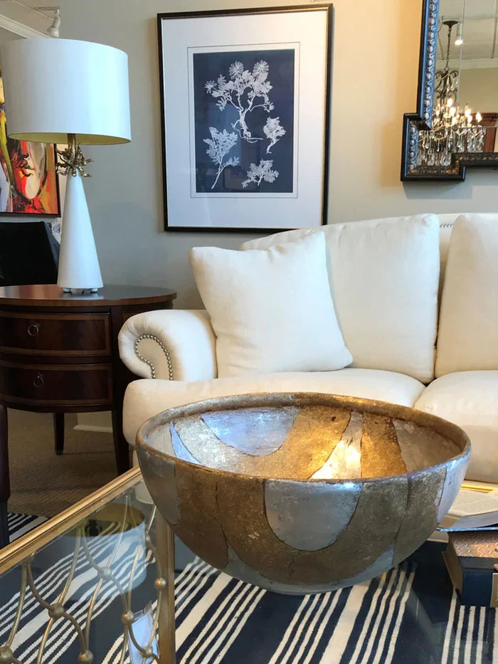 Living room with a white sofa, decorative table, and framed artwork.