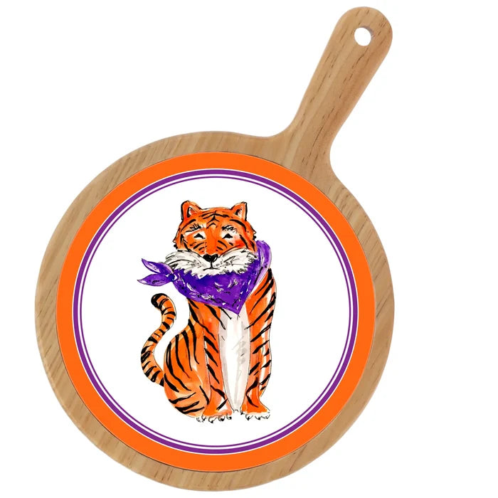 Round wooden cutting board with a tiger illustration wearing a purple scarf on a white background