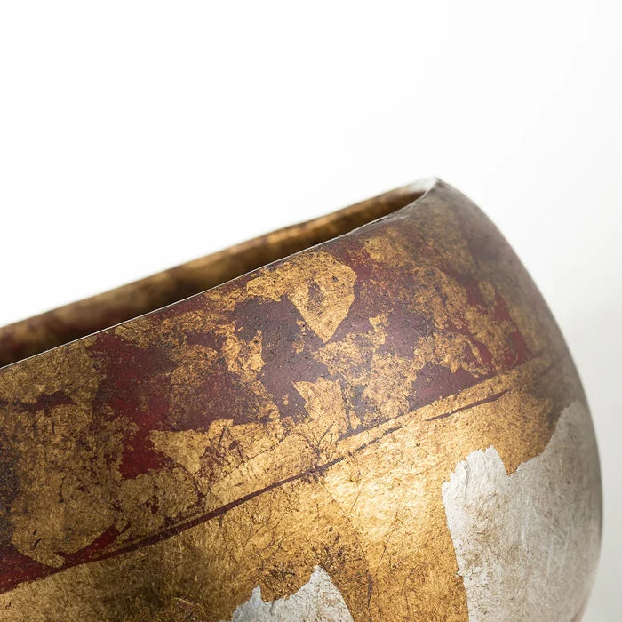 Close-up of a decorative bowl with gold and red patterns on a white background