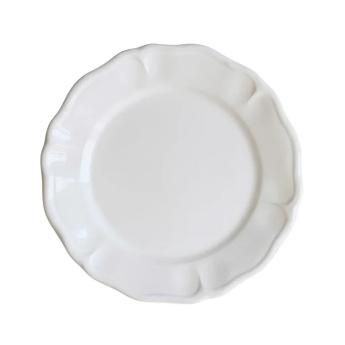White ceramic plate with decorative edge on a white background