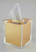 Gold and clear tissue box on a gray background