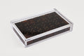 Clear plastic container with dark brown items on a light gray background