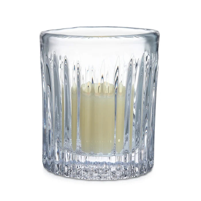 Clear glass candle holder with a candle inside on a white background