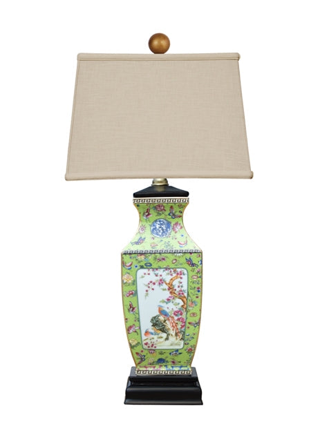 Decorative table lamp with a colorful ceramic base and beige lampshade on a white background